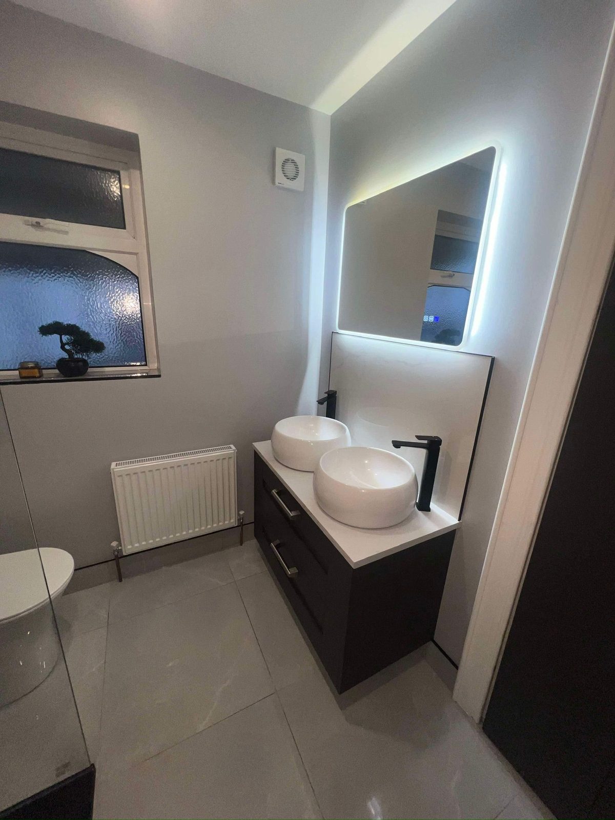 Dark-wood vanity with backlit mirror