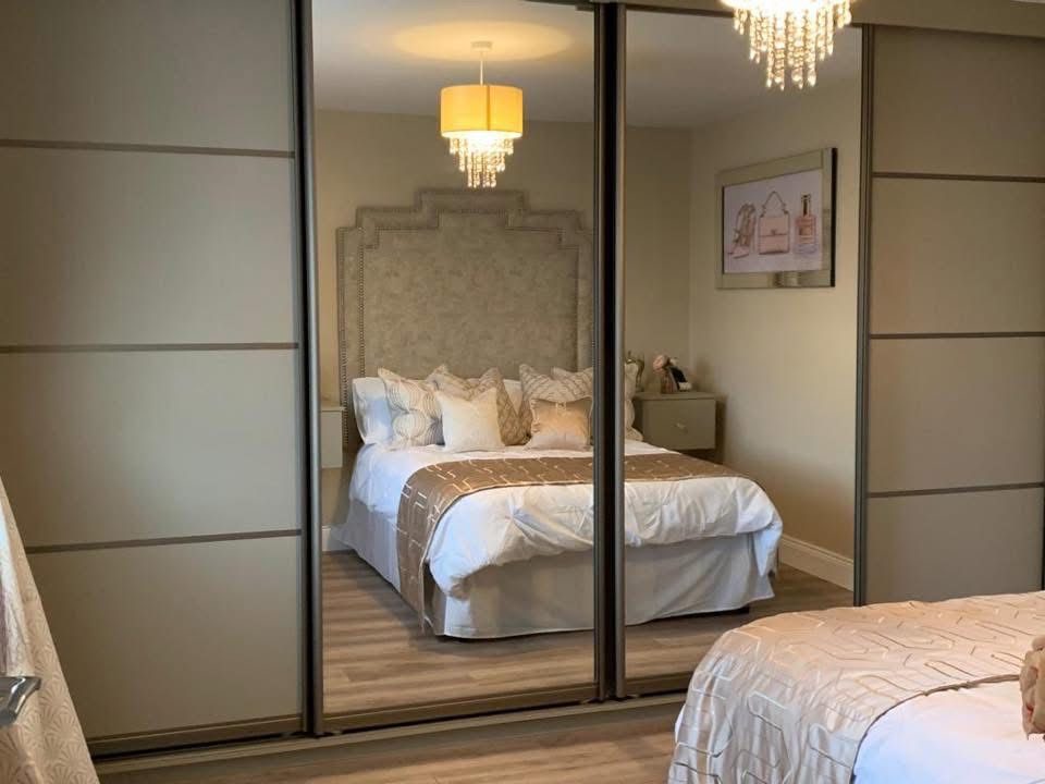 Sliding mirrored fitted wardrobes in a bedroom