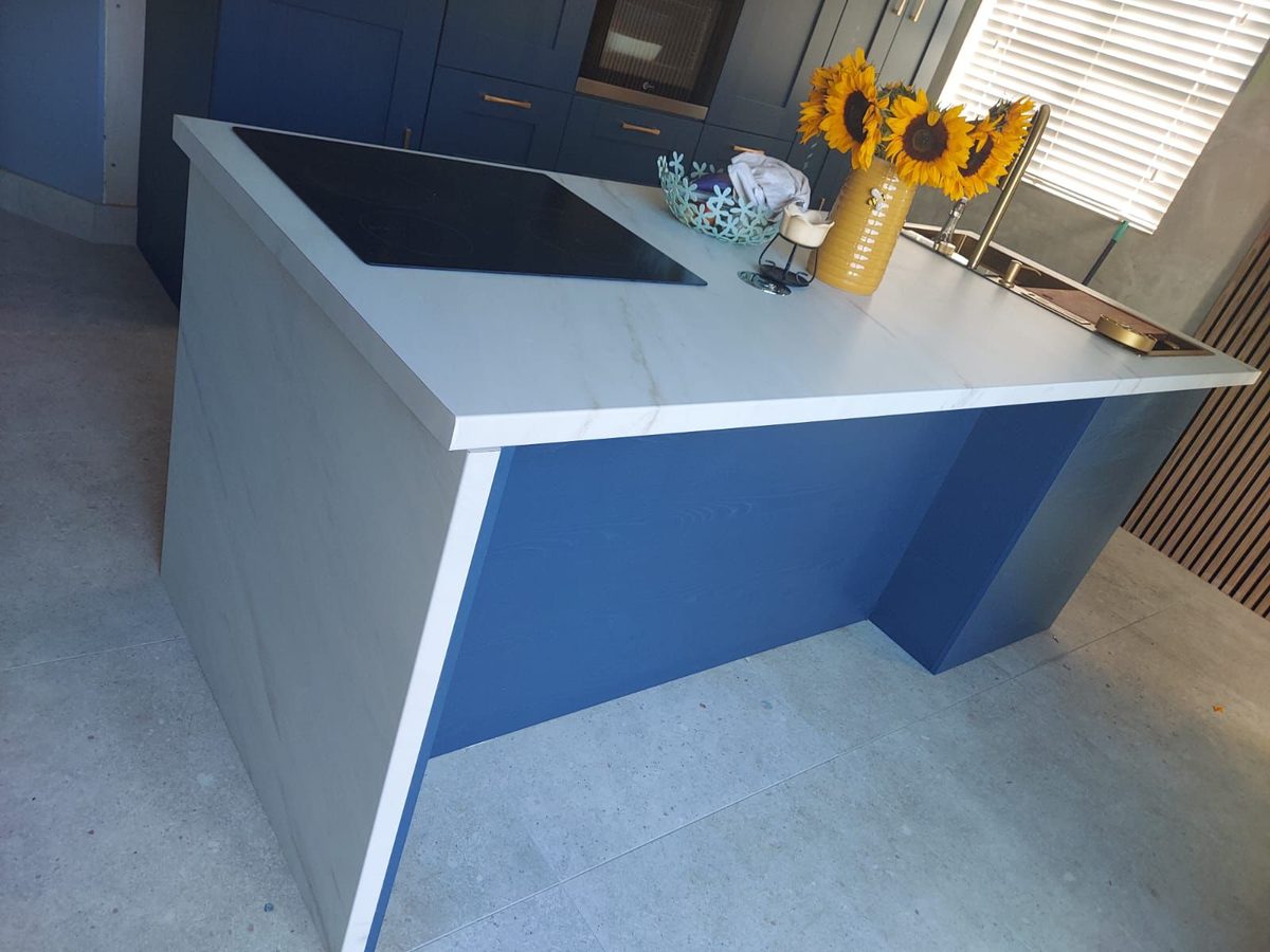 Navy shaker kitchen island with quartz worktop and brass tap